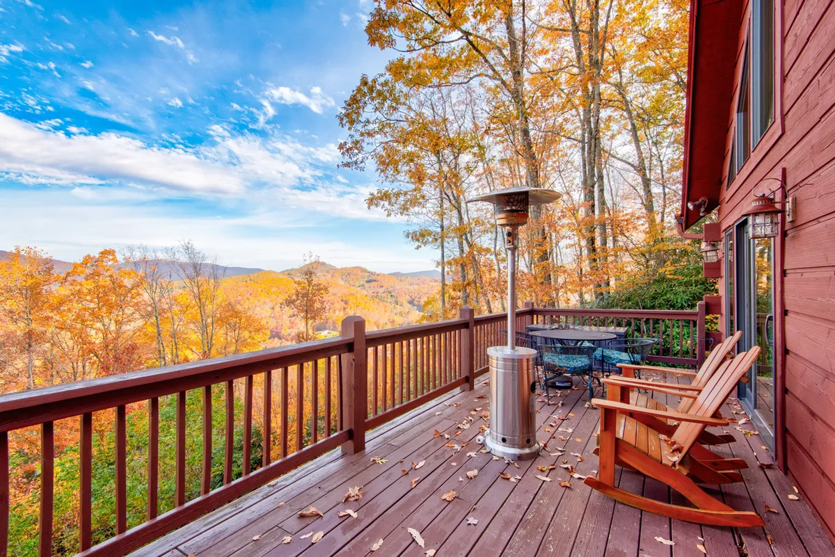 A scenic wooden deck with Adirondack chairs and an outdoor heater overlooks the mountains, providing a tranquil setting to relax, read, or watch the sunset. The openness and pet-friendly design invite guests and their dogs to soak up the natural beauty together.